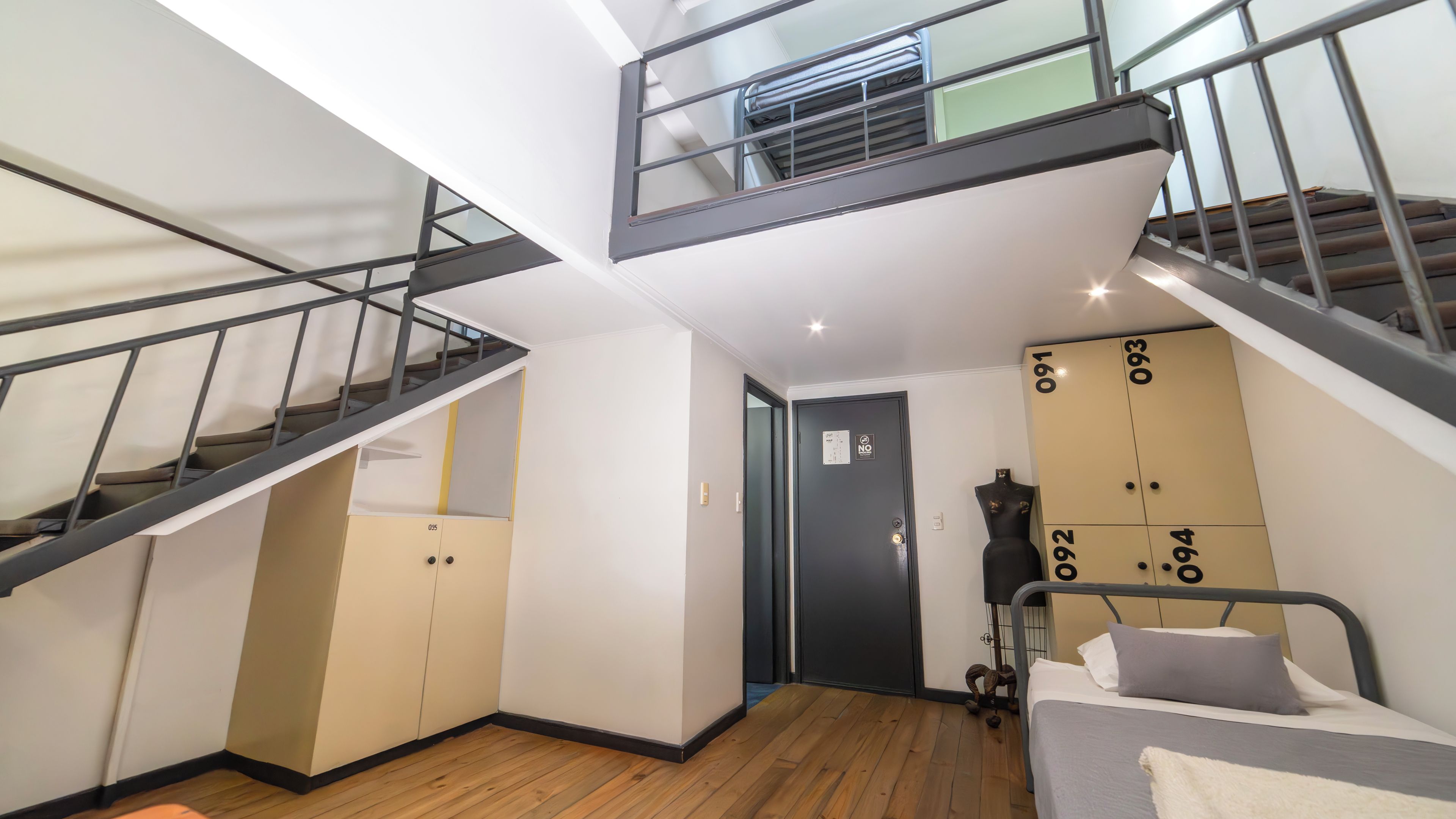A multi-level interior with a staircase, a bed with pillows, and a wardrobe with numbers on the doors.