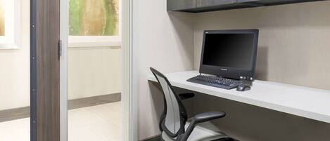 Un espacio de oficina moderno con un escritorio, una silla y un ordenador portátil.