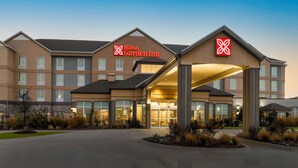 Un Hilton Garden Inn con un diseño moderno, que cuenta con un amplio toldo de entrada y una fachada bien iluminada.