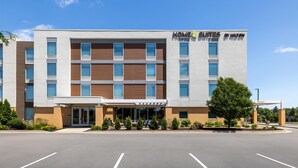Un hôtel moderne avec une enseigne indiquant « HOME 2 SUITES BY HILTON ».