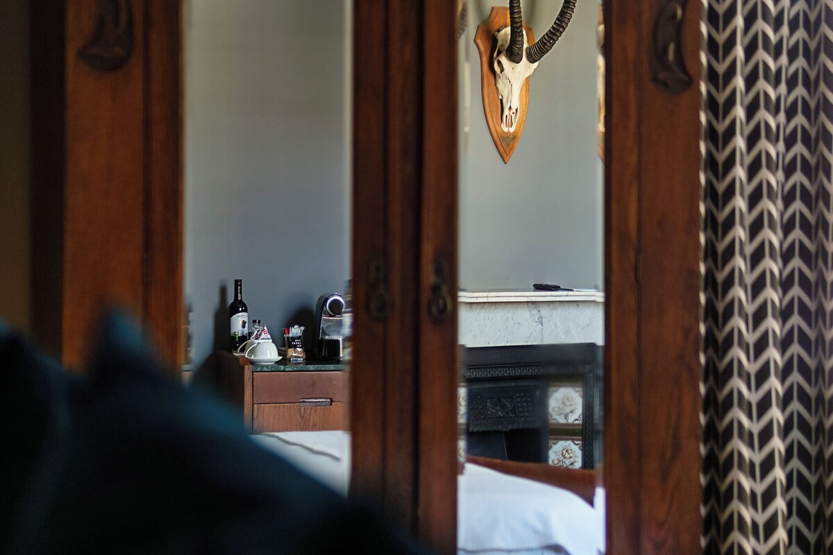 A room with a wooden door reflecting a skull mounted on the wall.