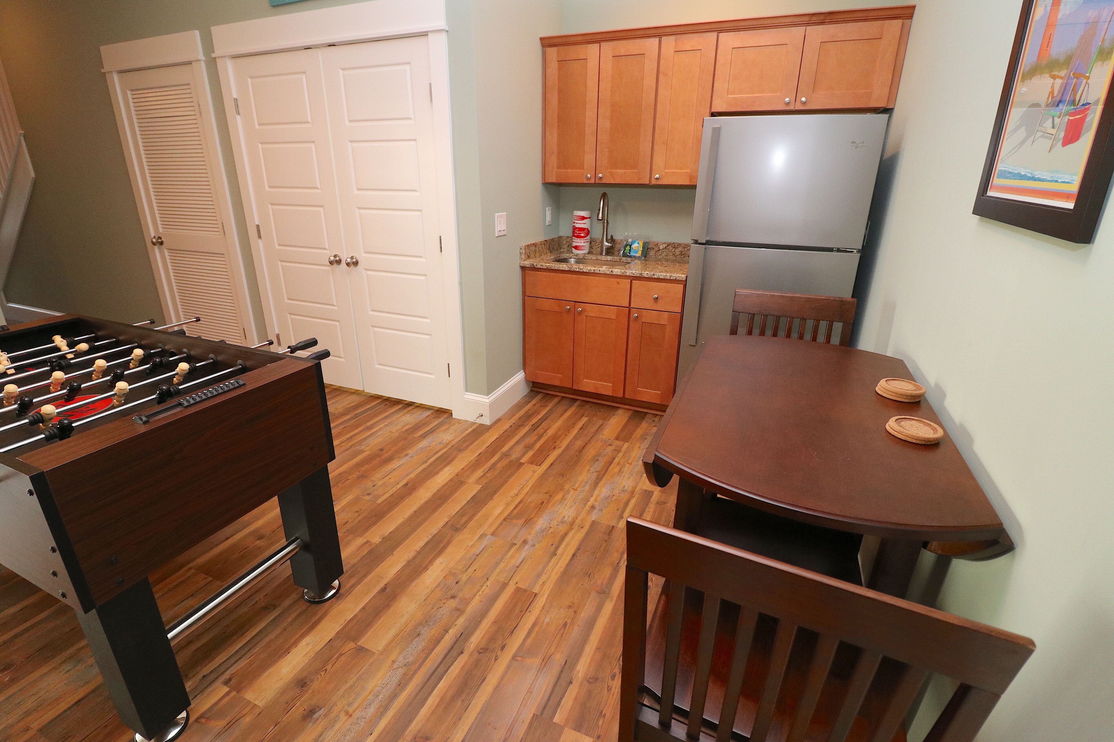 A kitchen with wooden cabinets, a refrigerator, and a dining table with chairs.