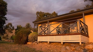 A building with a balcony, surrounded by trees and a rocky landscape. - Riesling Country Cottages (Polish Hill River)
