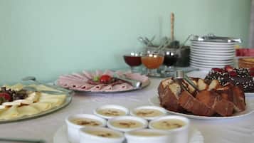 A buffet table with various food items including a cake, cheese, and small bowls of dips.