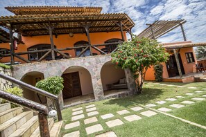 Un edificio con fachada de piedra, varios arcos y tejado de tejas.