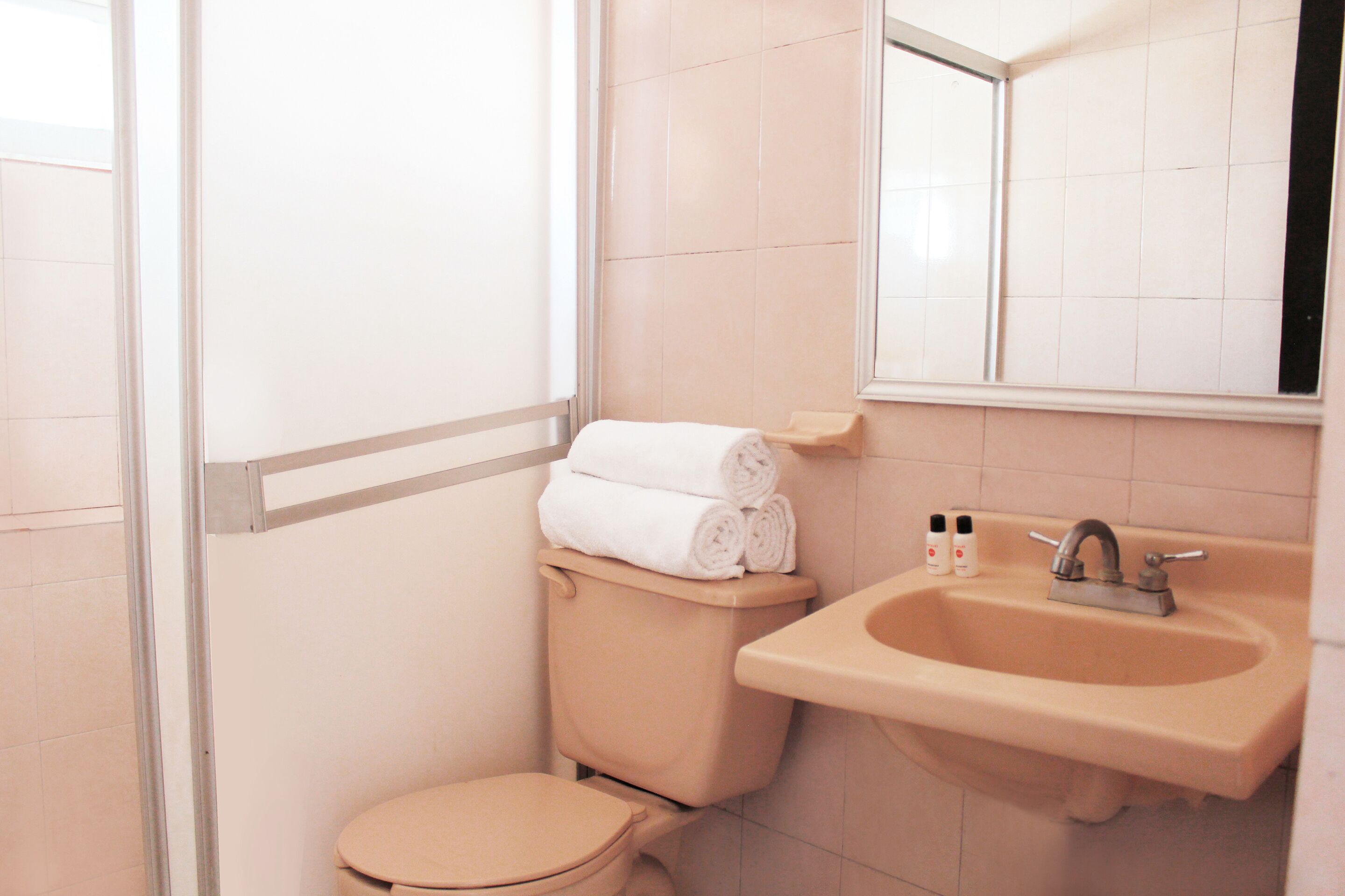 Un bagno con il water, un lavandino e uno specchio.