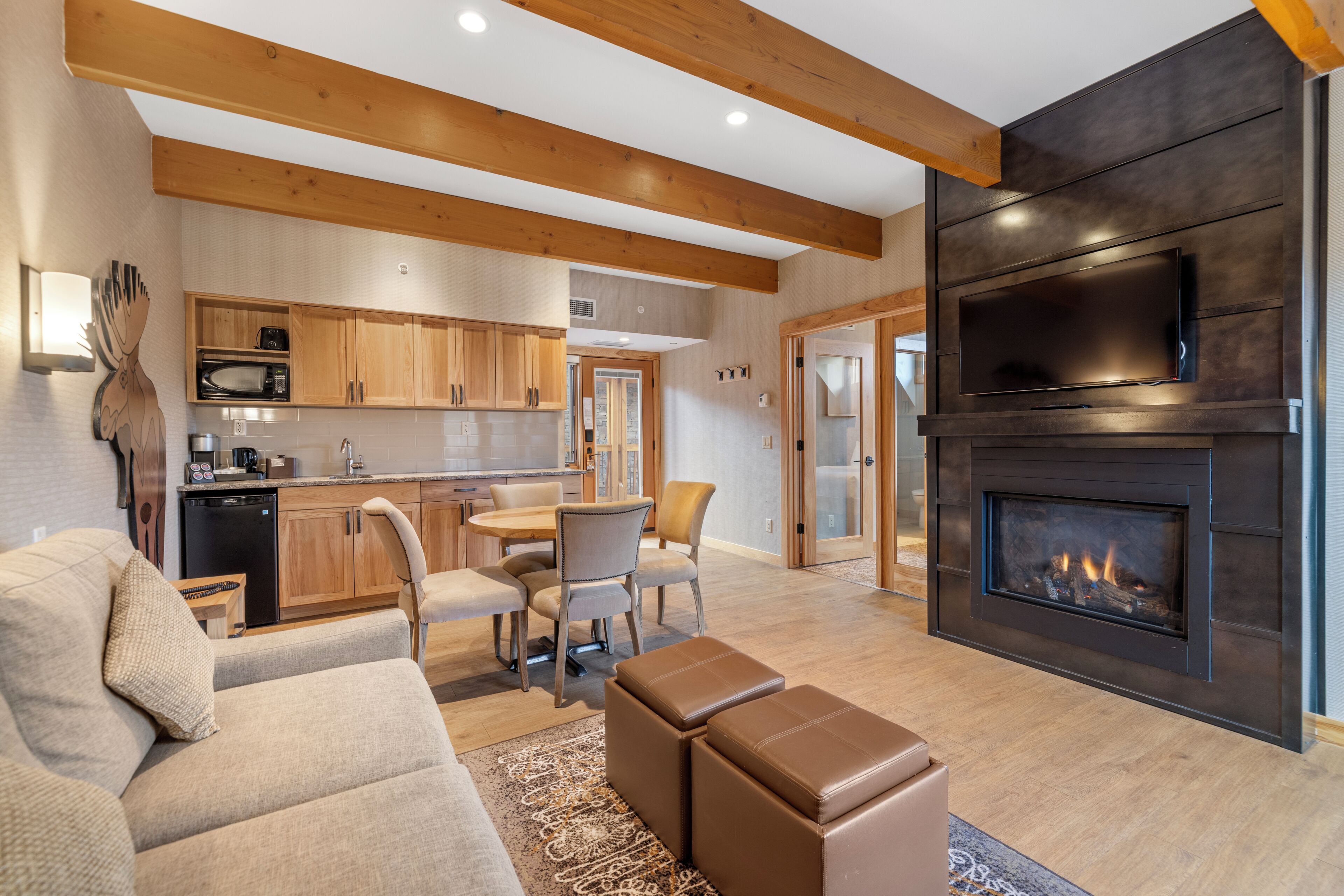 Una sala de estar moderna con chimenea, comedor y cocina.