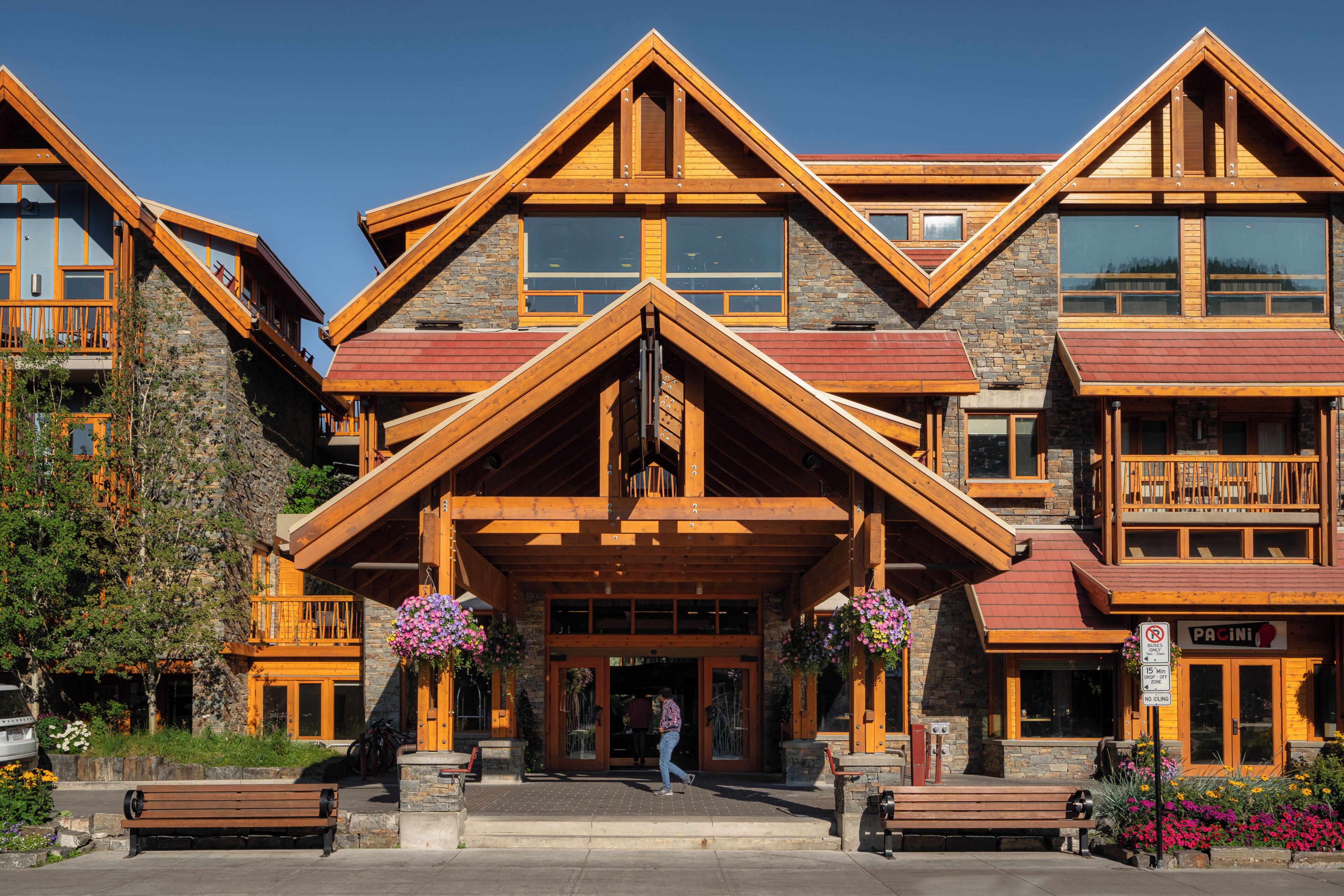 A multi-story lodge with a prominent entrance, stone facade, and wooden balconies.