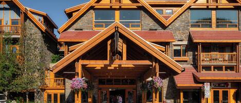 A multi-story lodge with a prominent entrance, stone facade, and wooden balconies.