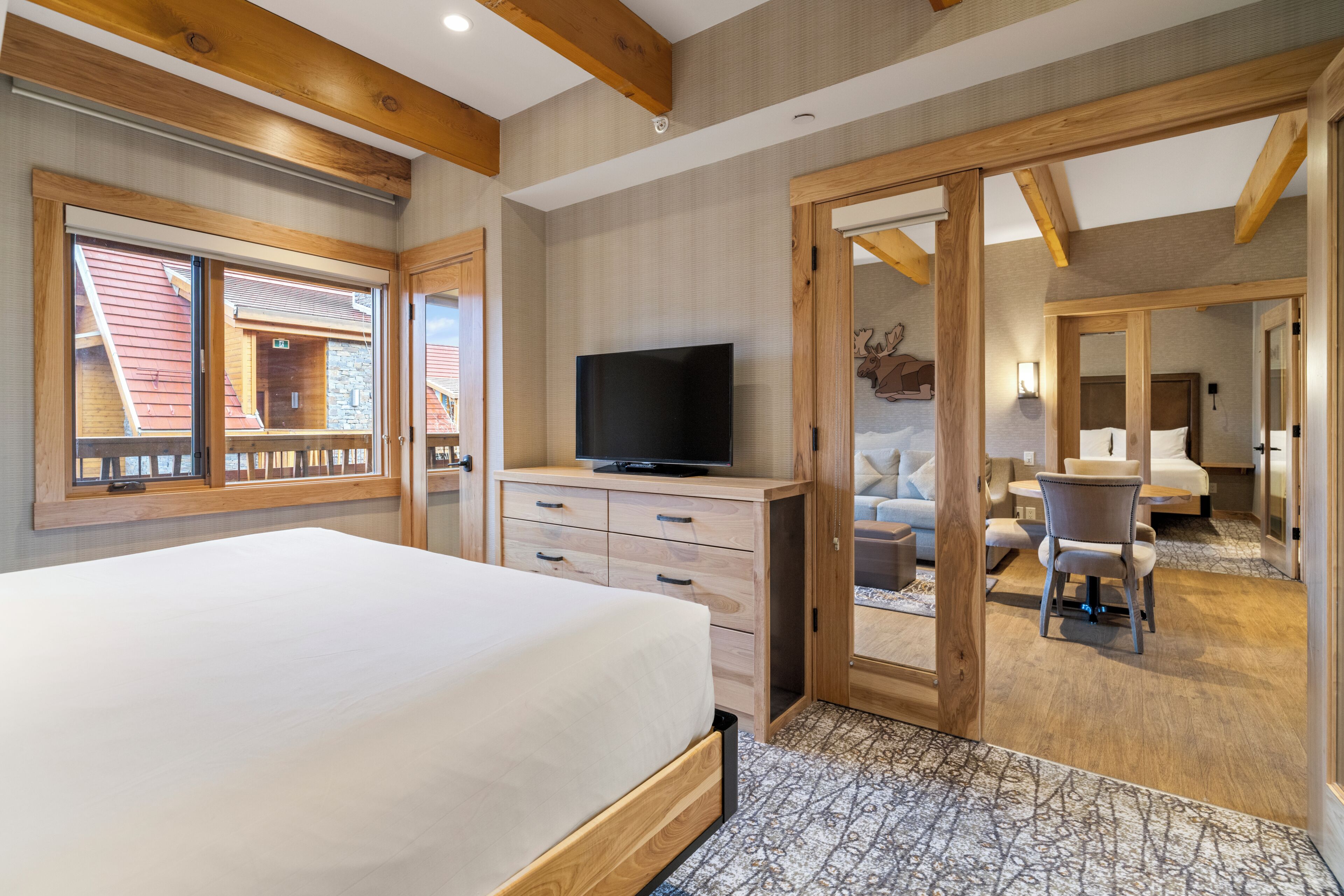 A bedroom with a bed, a television, a desk, and a chair.