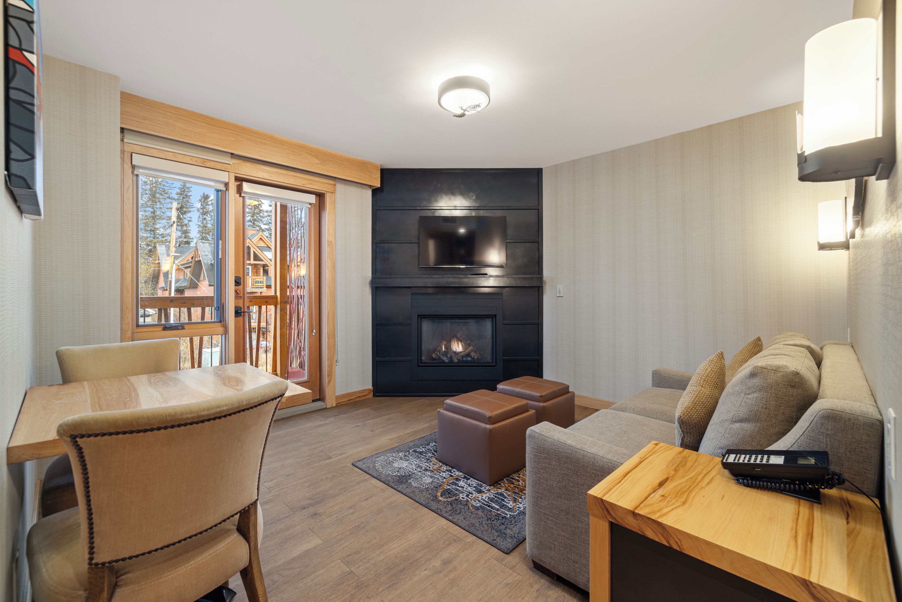 A modern living room with a fireplace, a dining area, and a sofa.