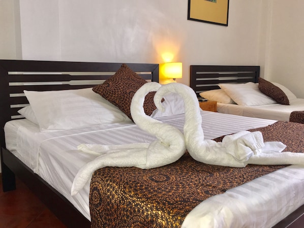A hotel room with a bed, pillows, a lamp, and a towel sculpture. - The Pub Hotel (Olongapo)