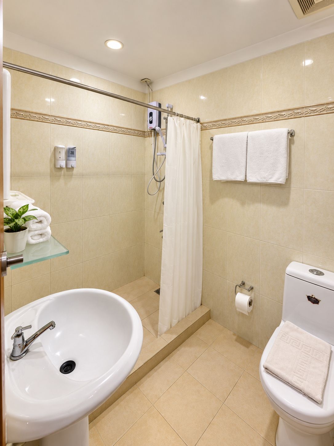 Ein Badezimmer mit Dusche, Toilette, Waschbecken und Handtuchhalter.