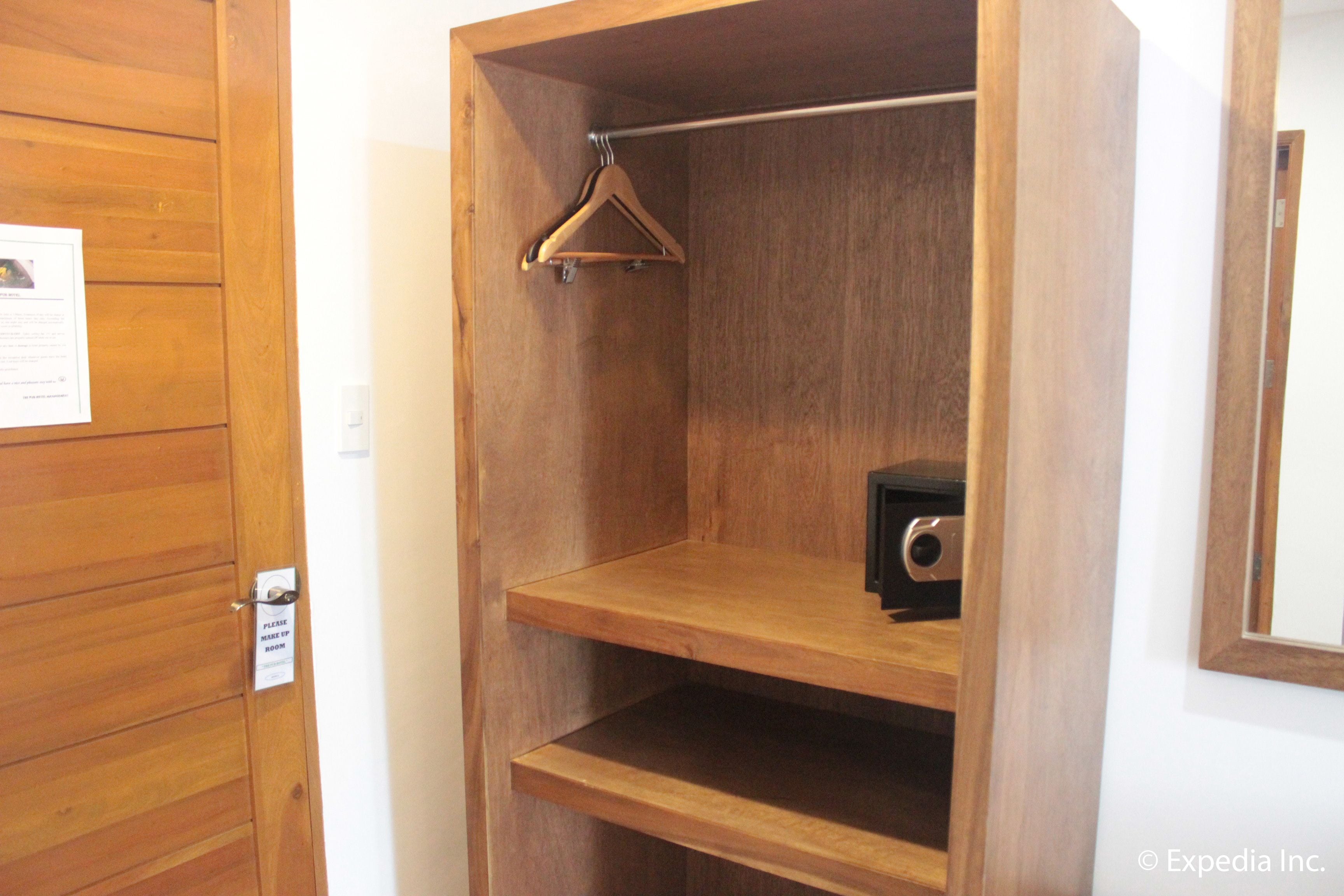 Un armario de madera con una barra para colgar y un estante pequeño.