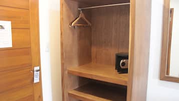 Un armario de madera con una barra para colgar y un estante pequeño.