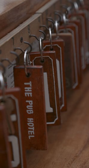 A row of metal lockers with tags hanging from them, each bearing a number. - The Pub Hotel (Olongapo)