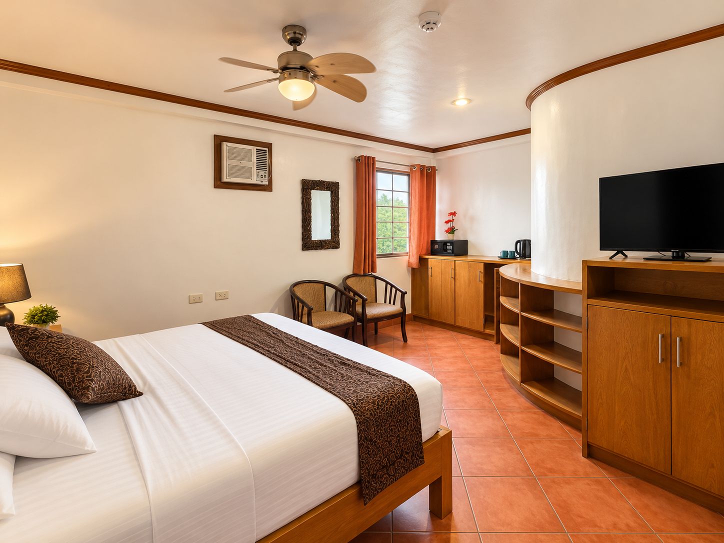 A hotel room with a bed, a desk, a television, and a ceiling fan.