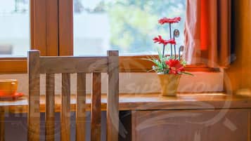 A wooden chair and a small table with a potted plant.