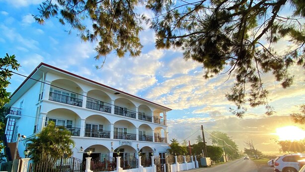 Un edificio de varios pisos con fachada blanca y balcones.