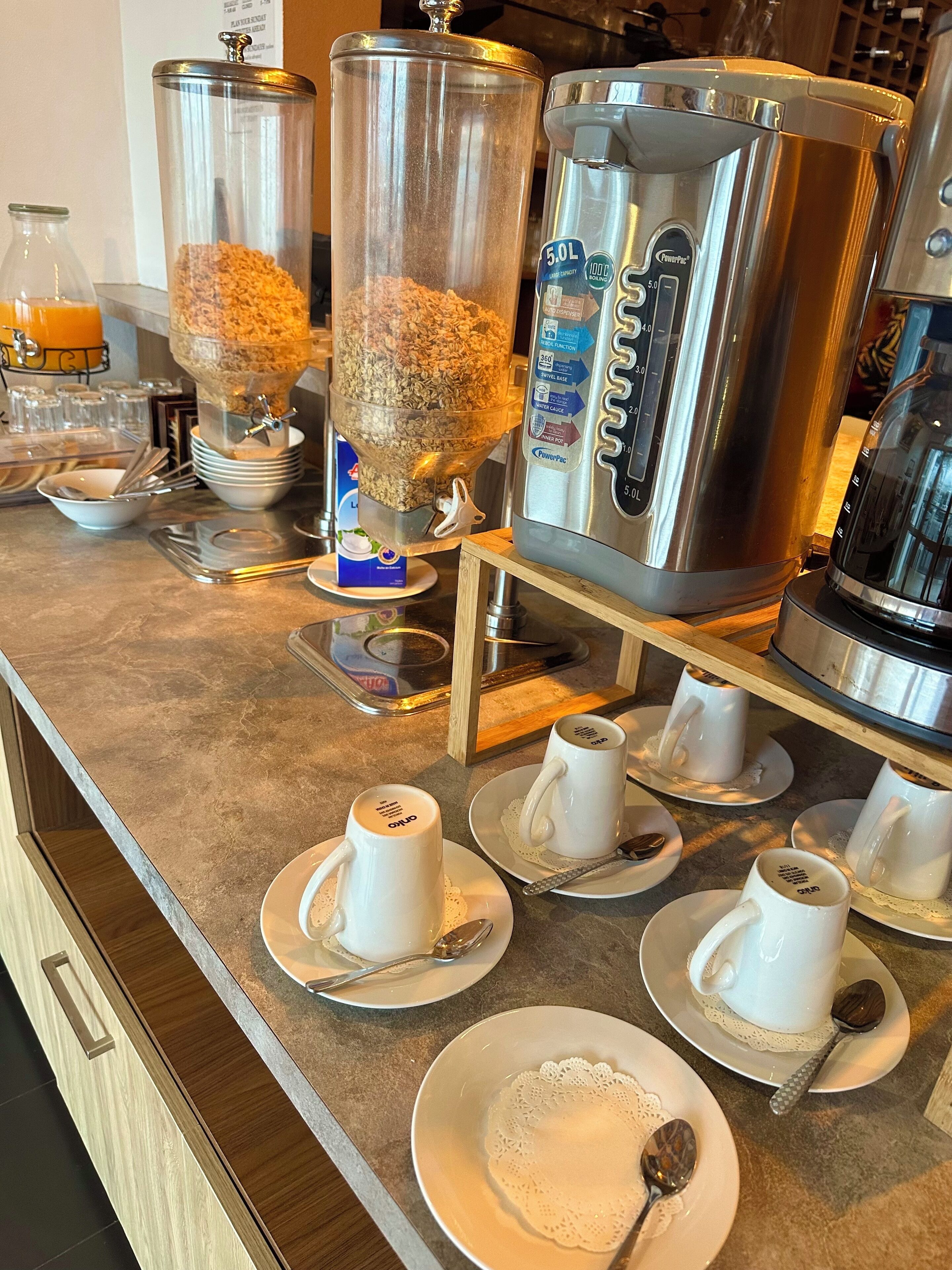A breakfast bar with a coffee maker, a cereal dispenser, and a water dispenser.