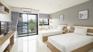 Ein modernes Hotelzimmer mit Balkon, Schreibtisch mit Stuhl, zwei Betten und einem Fernseher.