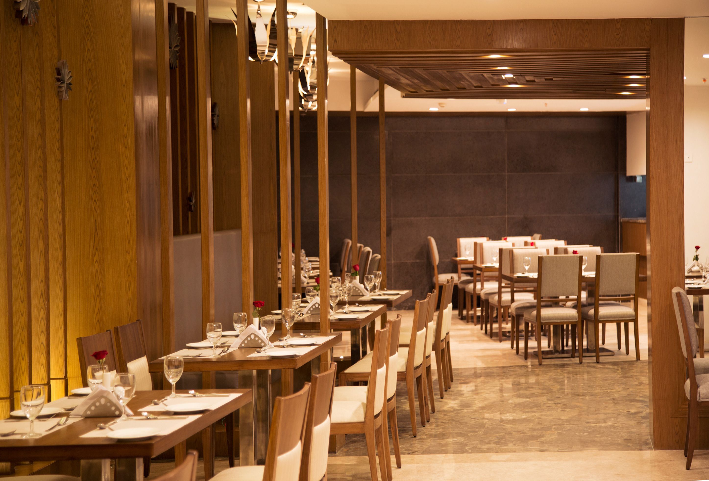 A restaurant with long wooden tables and chairs, arranged in a spacious layout.