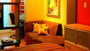 Ein Schlafzimmer mit Bett, Sofa, Schreibtisch und Schrank.
