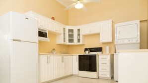 A kitchen with white cabinets, a refrigerator, an oven, a microwave, and a dishwasher.