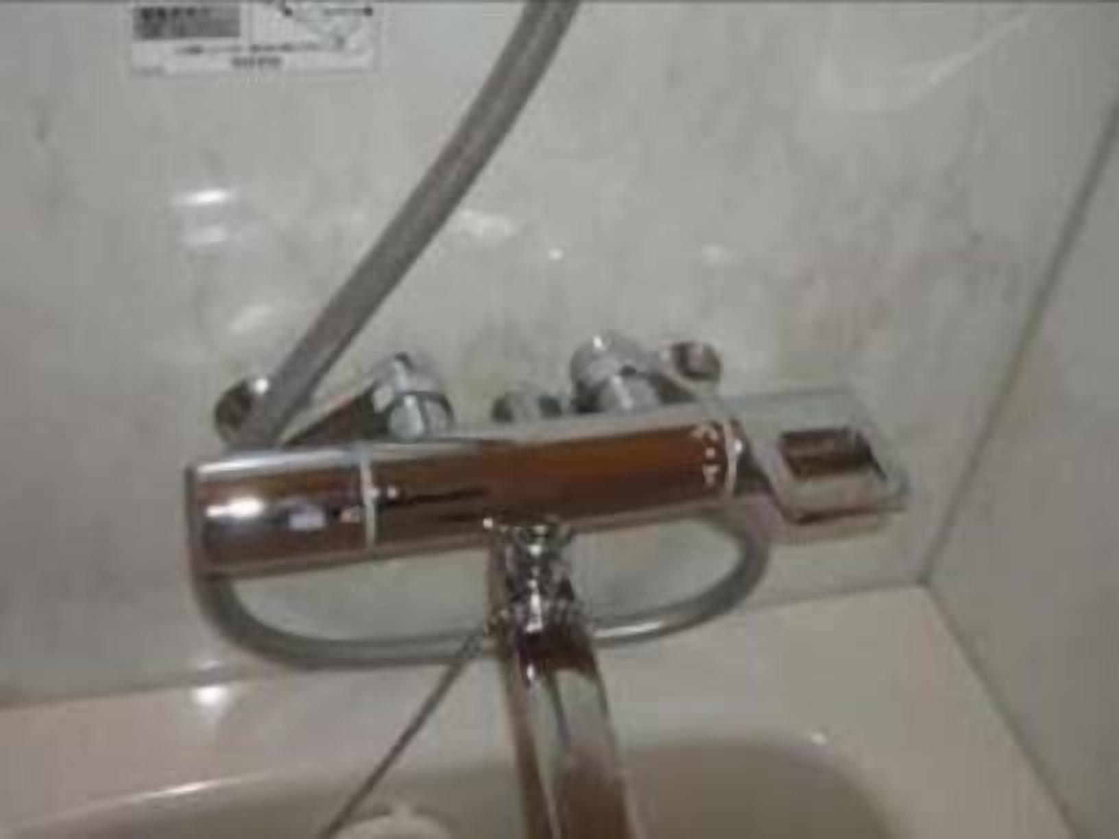 Ein Badezimmer mit Dusche, Spiegel und einem Handtuchhalter an der Wand.