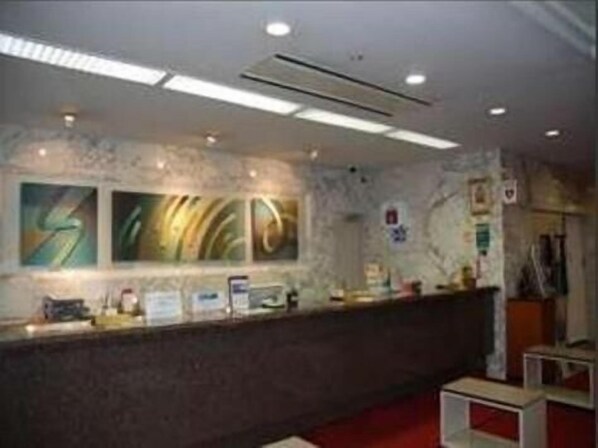 A reception area with a marble wall, artwork, a reception desk, and a red carpet. - Albert Hotel Akita (Akita)