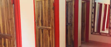 Un pasillo con puertas de madera y marcos rojos, que da a varias habitaciones.