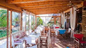 Un comedor de concepto abierto con vigas de madera, ventanas amplias y vistas al jardín.
