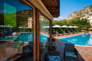 Alberca al aire libre, sombrillas en la alberca y camastros