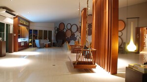 Un interior moderno con una recepción, un área de asientos cómodos y una decoración de pared original con espejos circulares.