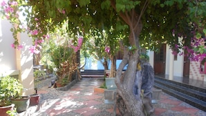 A courtyard with a tiled floor, potted plants, and a statue. - Suoi Nuoc Resort (Mui Ne)