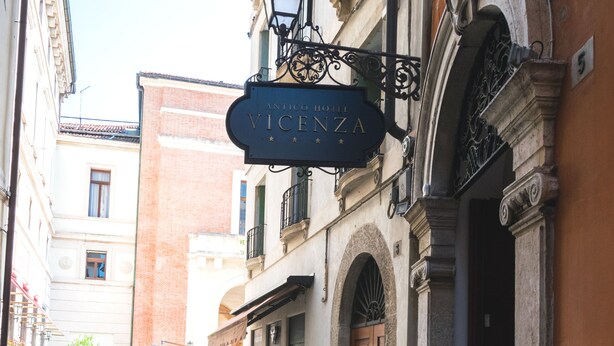 Een straat met cobblestones, met een gebouw dat een bord voor 'Antico Vinca' heeft.