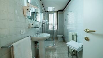 Un baño con lavamanos, inodoro y ducha.