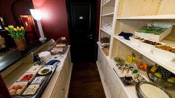 Ein Buffet mit verschiedenen Speisen und einer schwarzen Tür im Hintergrund.