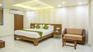 Ein modernes Schlafzimmer mit einem hölzernen Bett, einem Nachttisch, einer Couch und einem Deckenventilator.