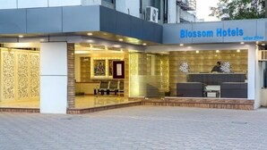 Das äußere Erscheinungsbild des Blossom Hotels mit einer Rezeption, einer Sitzecke und dekorativen Paneelen.