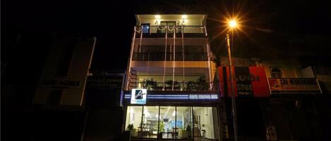 A multi-story building with a ground-floor restaurant and upper-floor balconies.