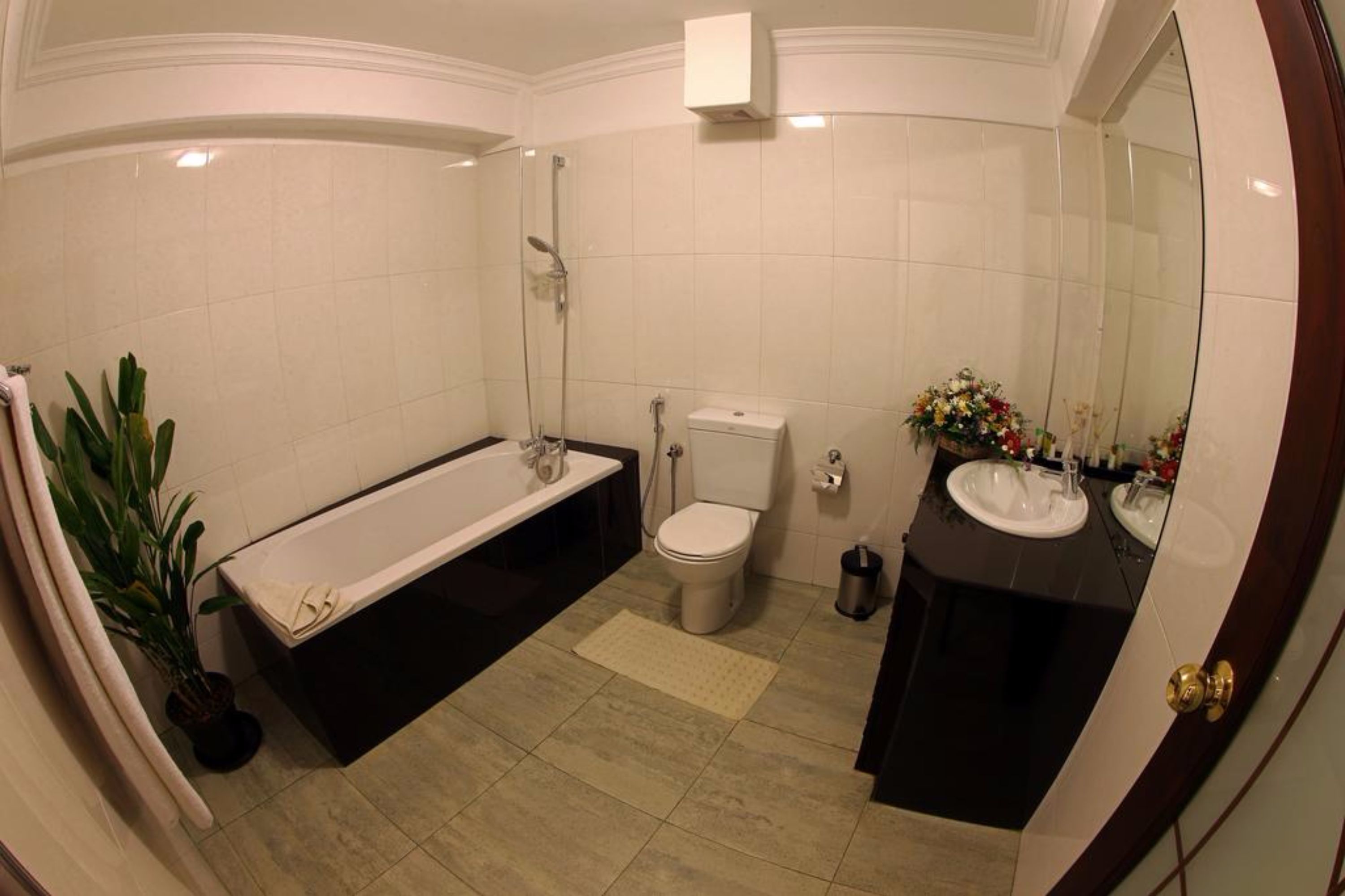 A bathroom with a bathtub, toilet, and two sinks.