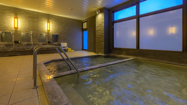 Un área de spa con un jacuzzi, paredes de madera y ventanas grandes.