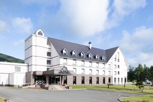 A large, modern hotel with a symmetrical facade, multiple windows, and a prominent entrance with a covered walkway.