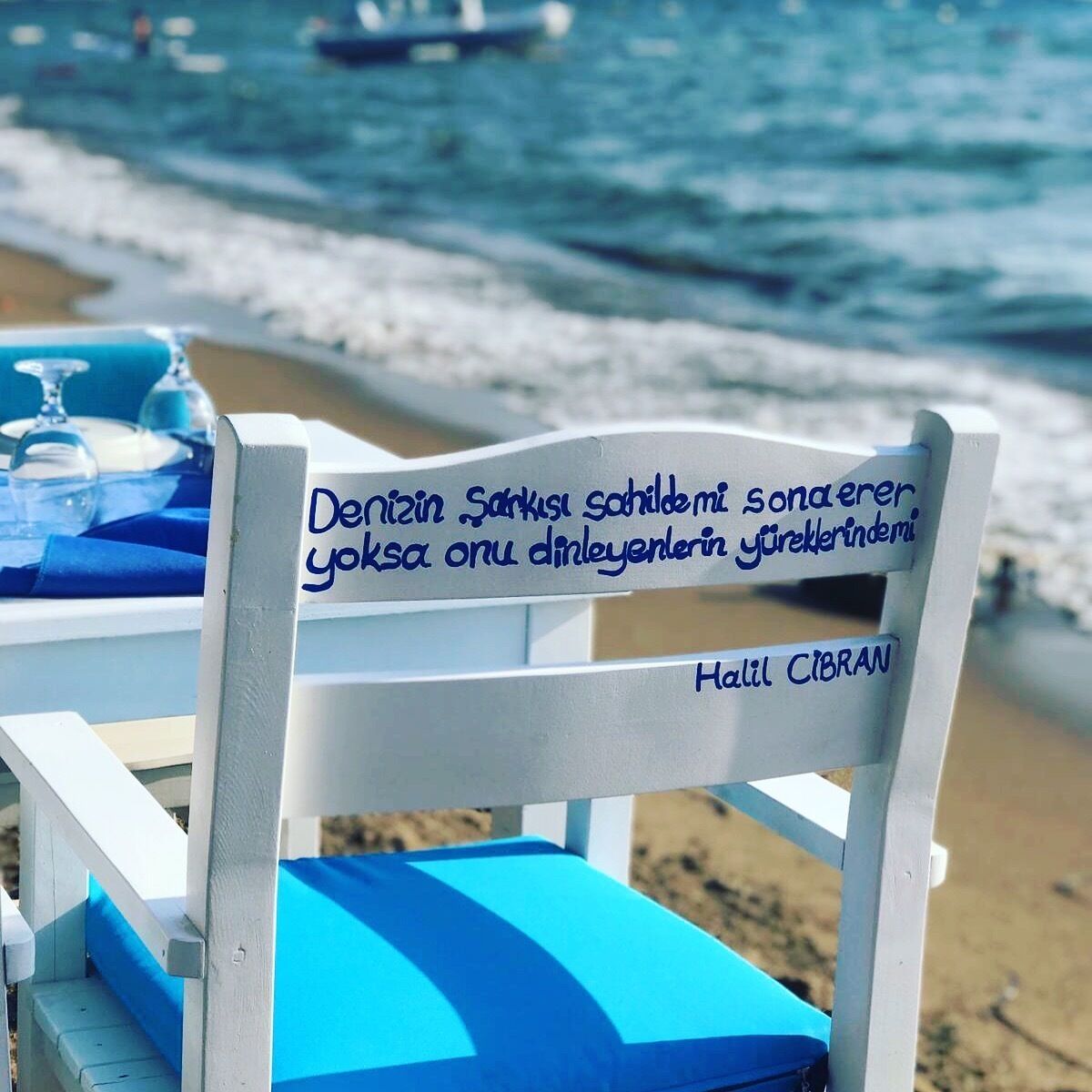 A beach chair with a handwritten message in Turkish.