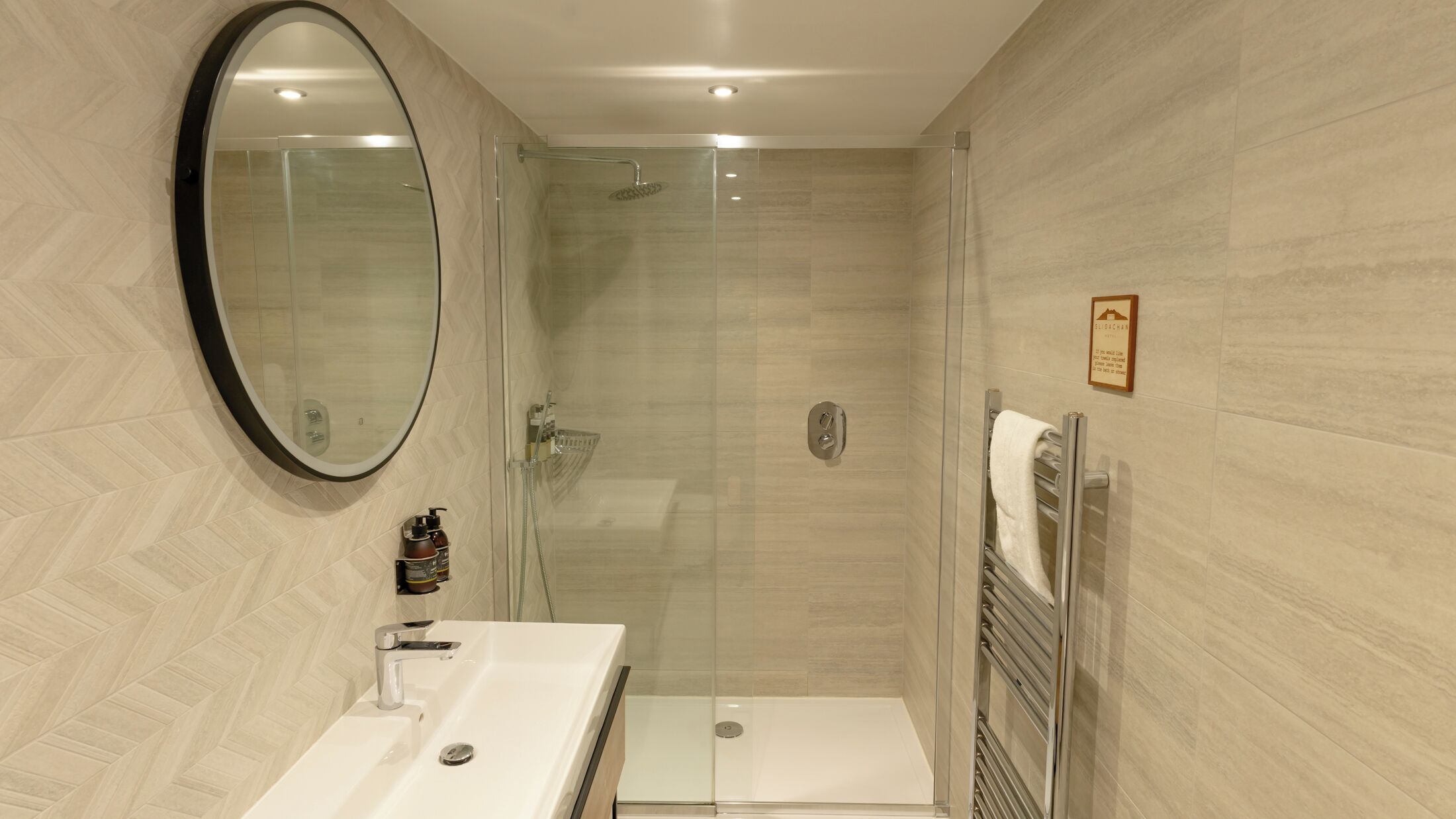 A modern bathroom with a shower, a sink, and a mirror.