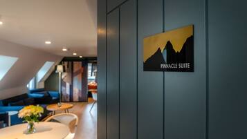 A Pinnacle Suite sign in a modern hotel lobby with a dining area and seating.