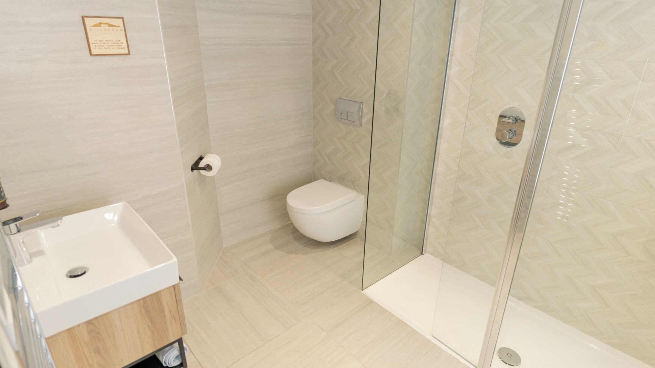 A modern bathroom with a shower enclosure, a toilet, and a sink.