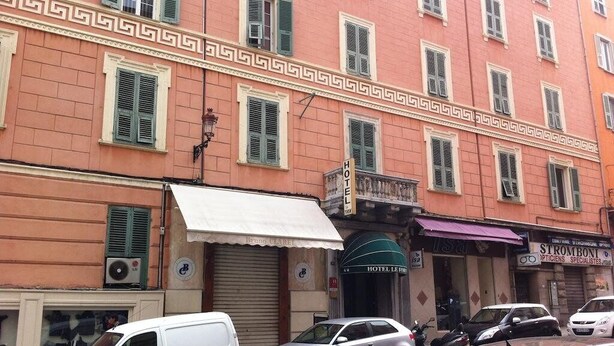 A multi-story building with a row of windows, a white awning, and a sign for a hotel. - Hotel Le Forum (Bastia)