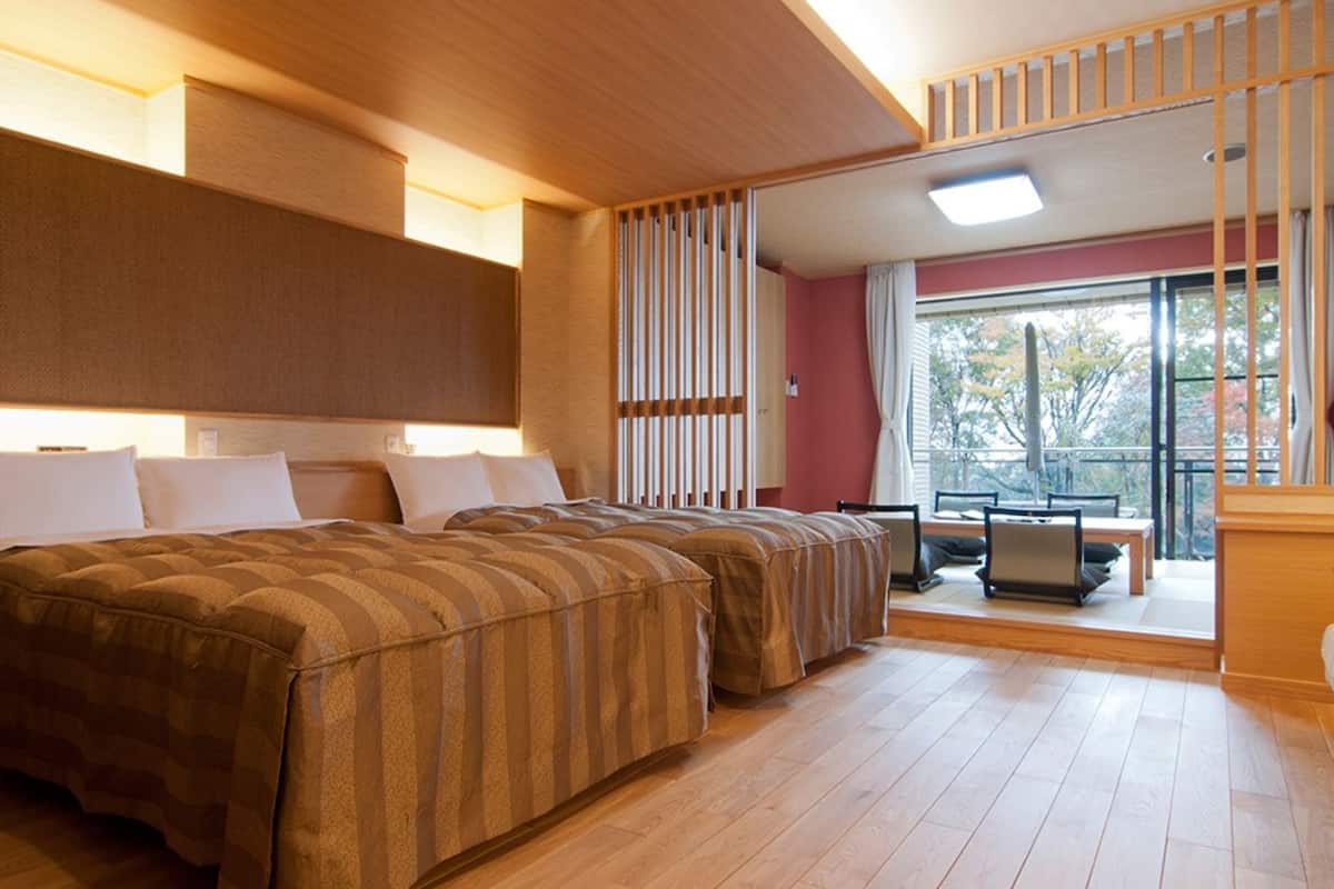 A hotel room with a large bed, a desk, and a view of the outdoors.